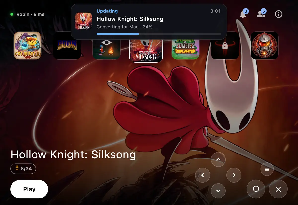 The phone showing the Mac updating Silksong, 34 percent